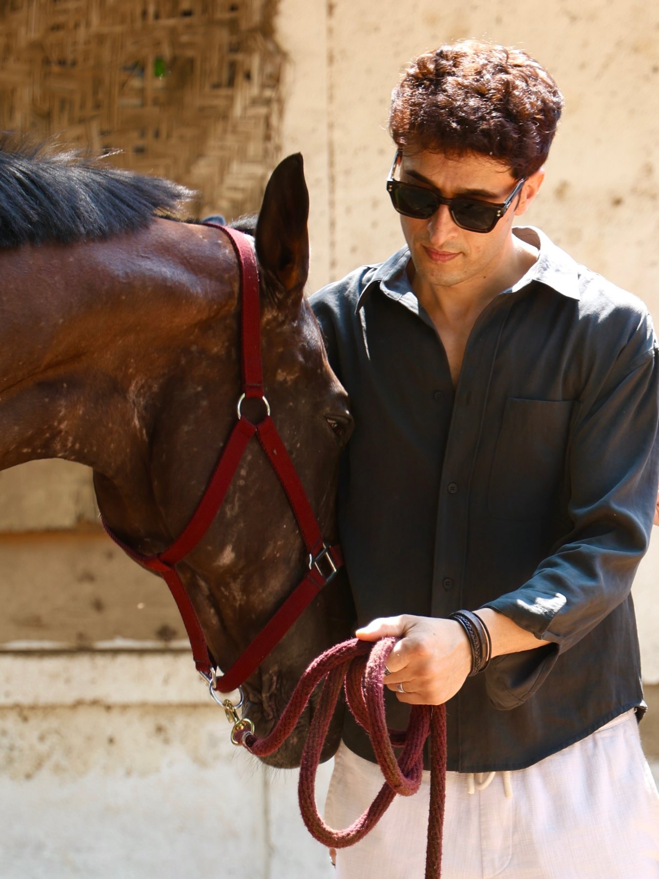 Raff in a dark fashion portrait beside a horse