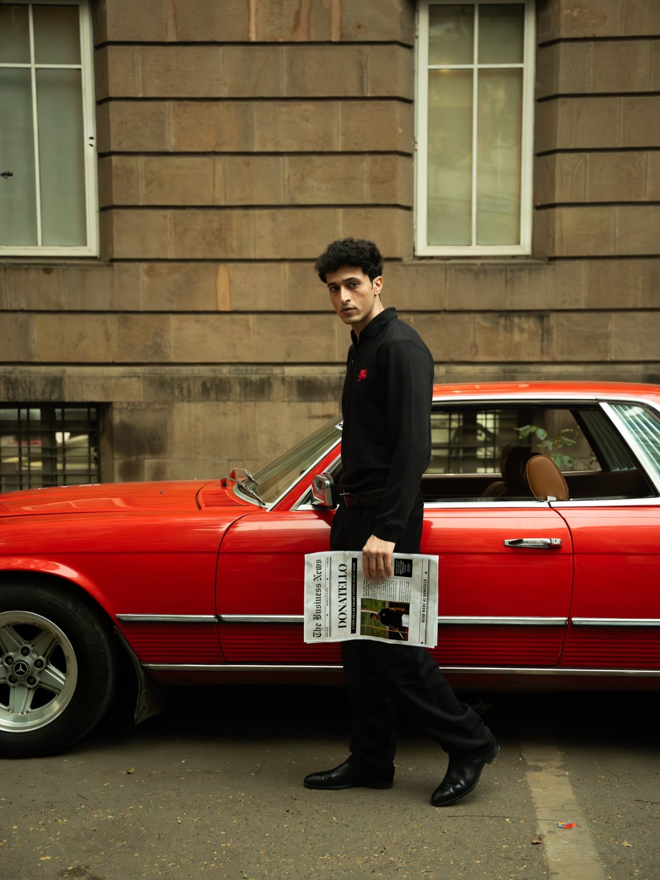 Raff beside a red car on a city street